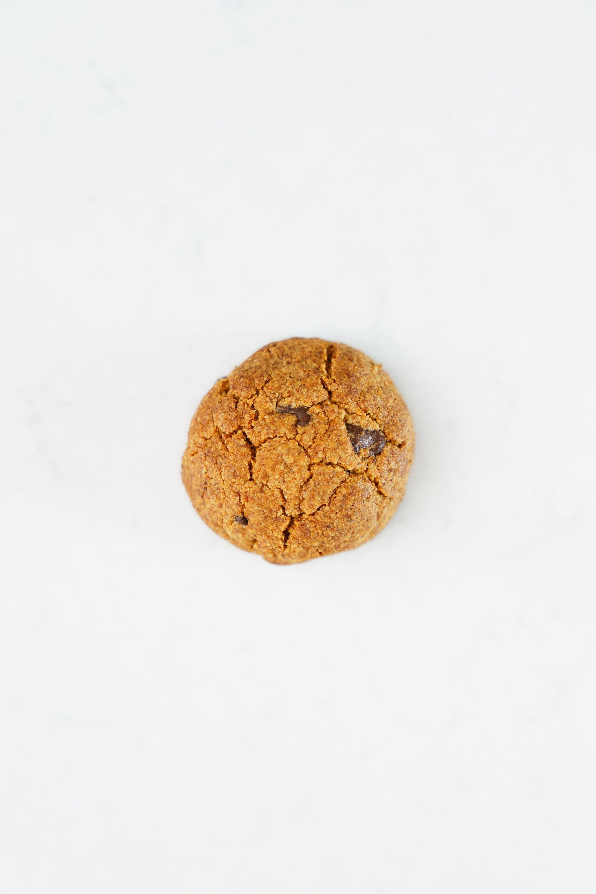 Four gluten-free vegan chocolate-chip cookies from Heaven Gluten Free Bakery on a plate, showcasing their chewy texture and chocolate chips