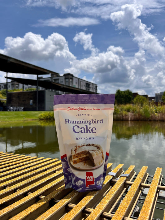 Hummingbird cake mix by WE Made featuring a ready-to-bake box with vibrant fruit and nut ingredients on the packaging.