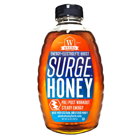 A plastic bottle of Surge Honey™ by Weeks Honey Farm, made with raw, unfiltered USA honey and Himalayan Pink Salt, serves as an energy and electrolyte boost for athletes pre/post workout; blue and orange label.