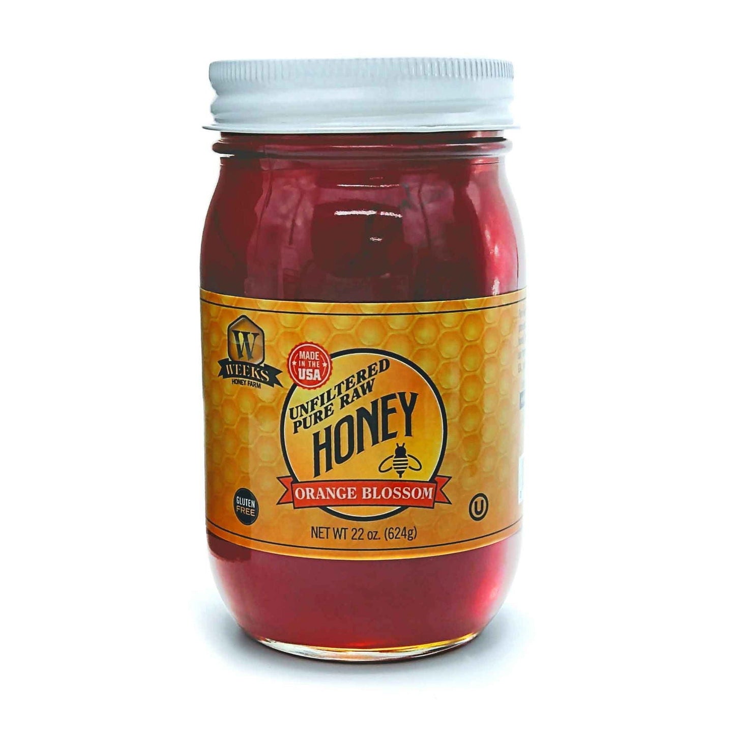 Glass jar of Weeks Naturals pure raw orange blossom honey showing golden honey with a honey dipper on top.
