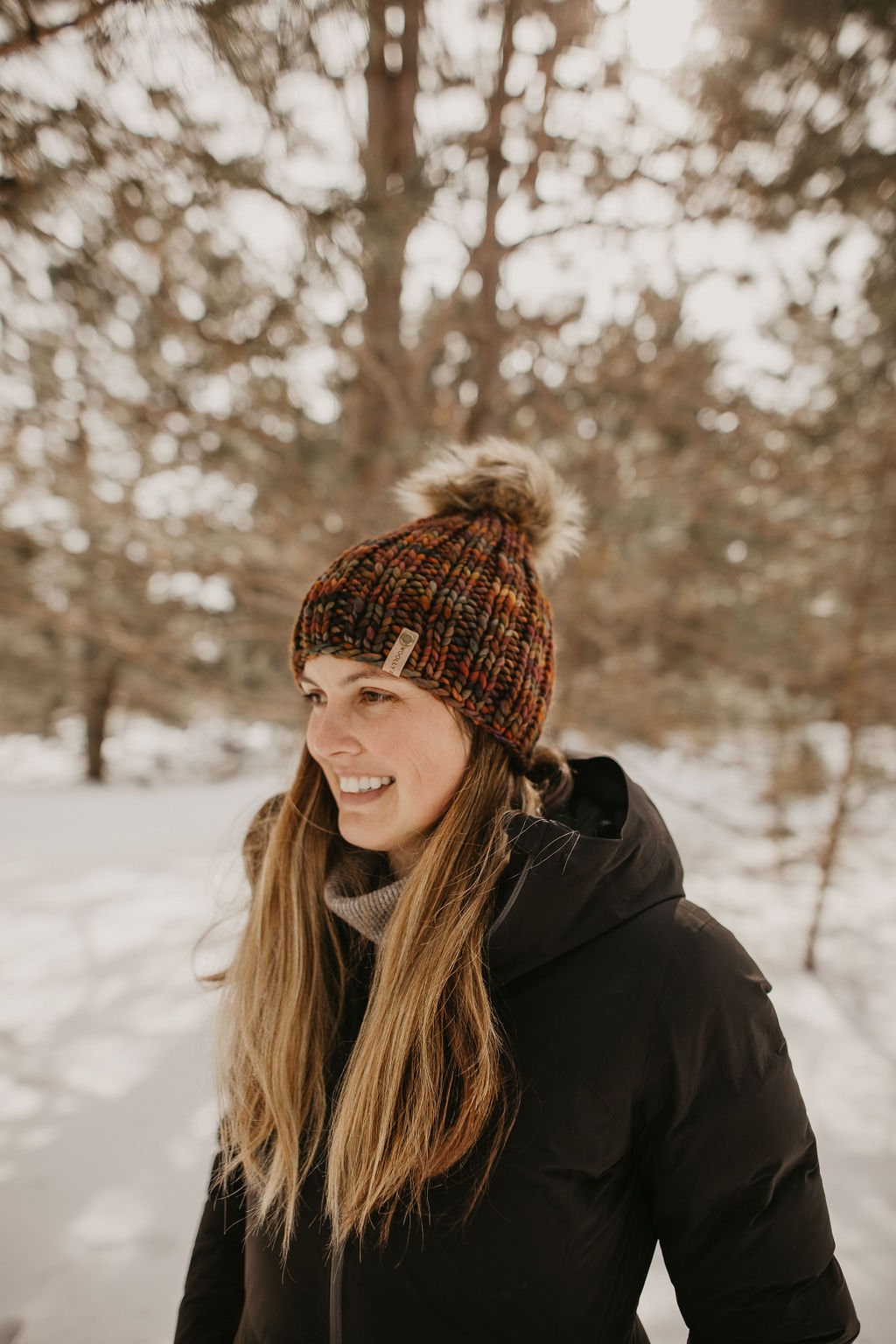 Brown multi-color merino wool ribbed knit hat with faux fur pom-pom by Woolly Bear Knits, cozy winter accessory.