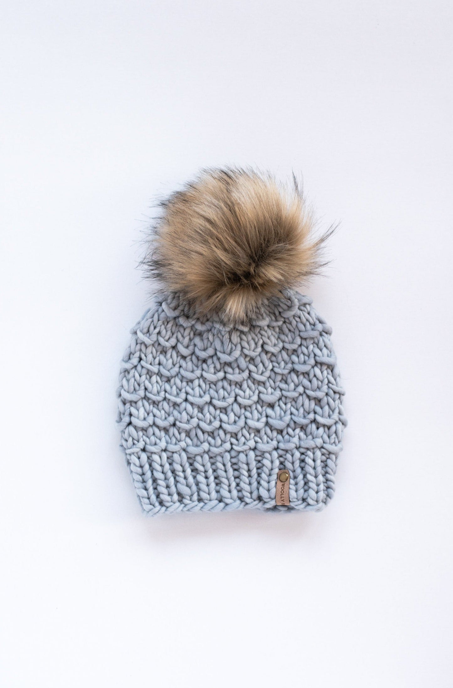 Gray Merino Wool Knit Hat with Faux Fur Pom Pom by Woolly Bear Knits, showcasing soft, warm wool and a fluffy pom on top.