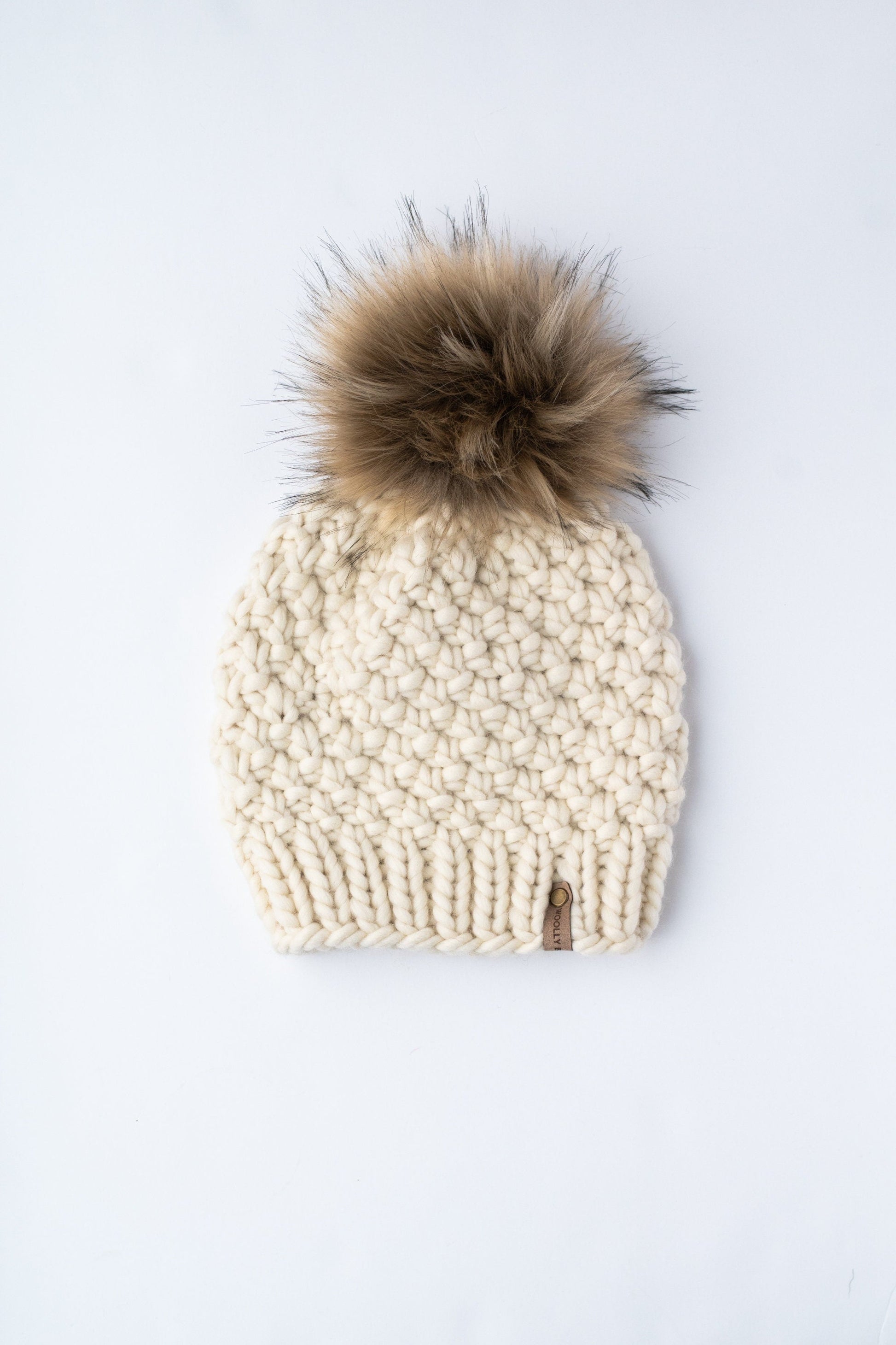 Ivory Peruvian wool knit hat with faux fur pom pom from Woolly Bear Knits, featuring a cozy, textured wool design.
