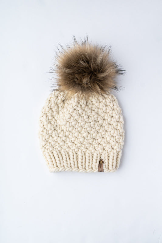 Ivory Peruvian wool knit hat with faux fur pom pom from Woolly Bear Knits, featuring a cozy, textured wool design.