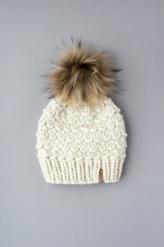 Ivory Peruvian wool knit hat with faux fur pom-pom by Woolly Bear Knits, featuring a cozy, textured design and fluffy pom accessory.