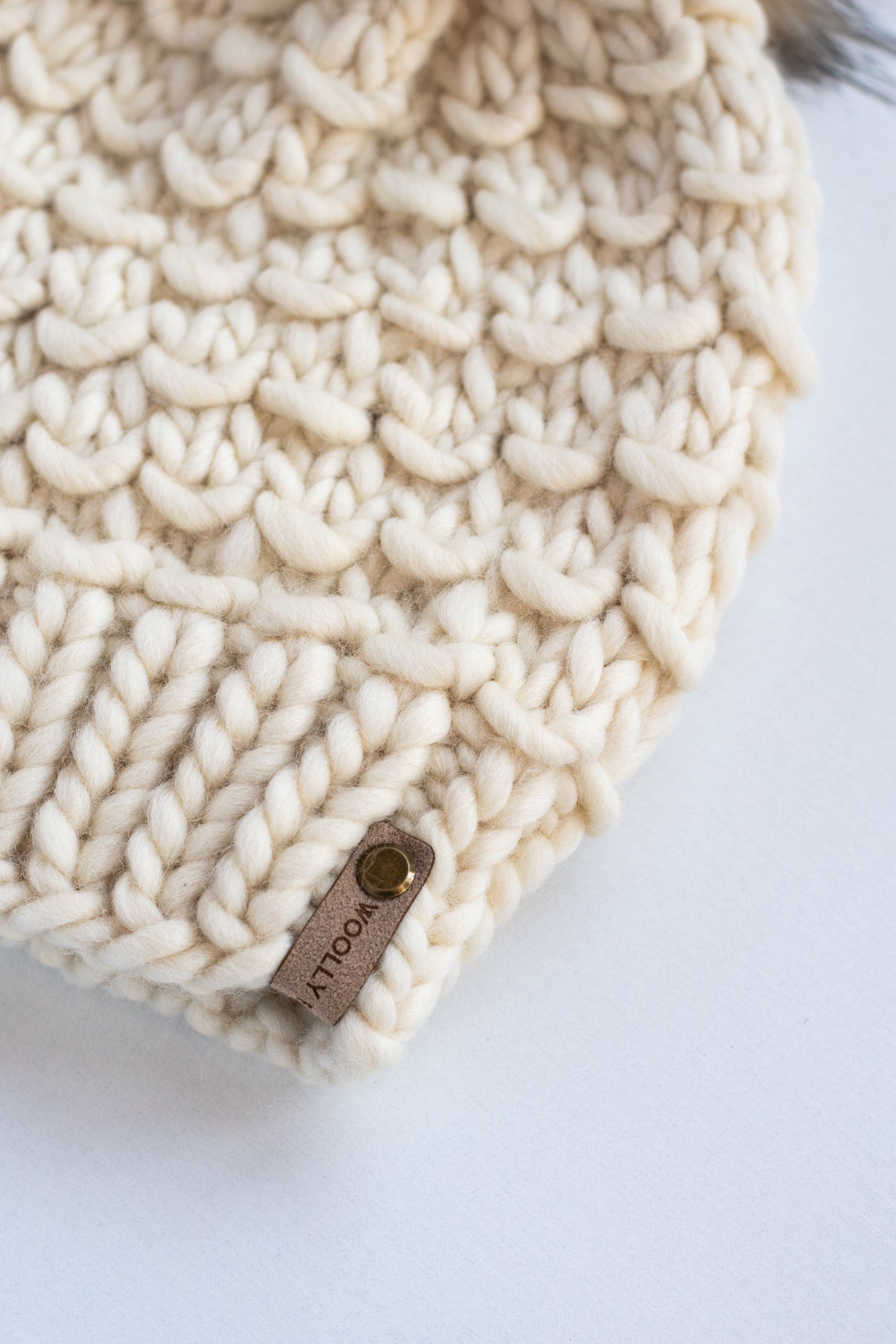 Ivory Peruvian wool knit hat with faux fur pom-pom from Woolly Bear Knits, cozy and warm winter accessory.