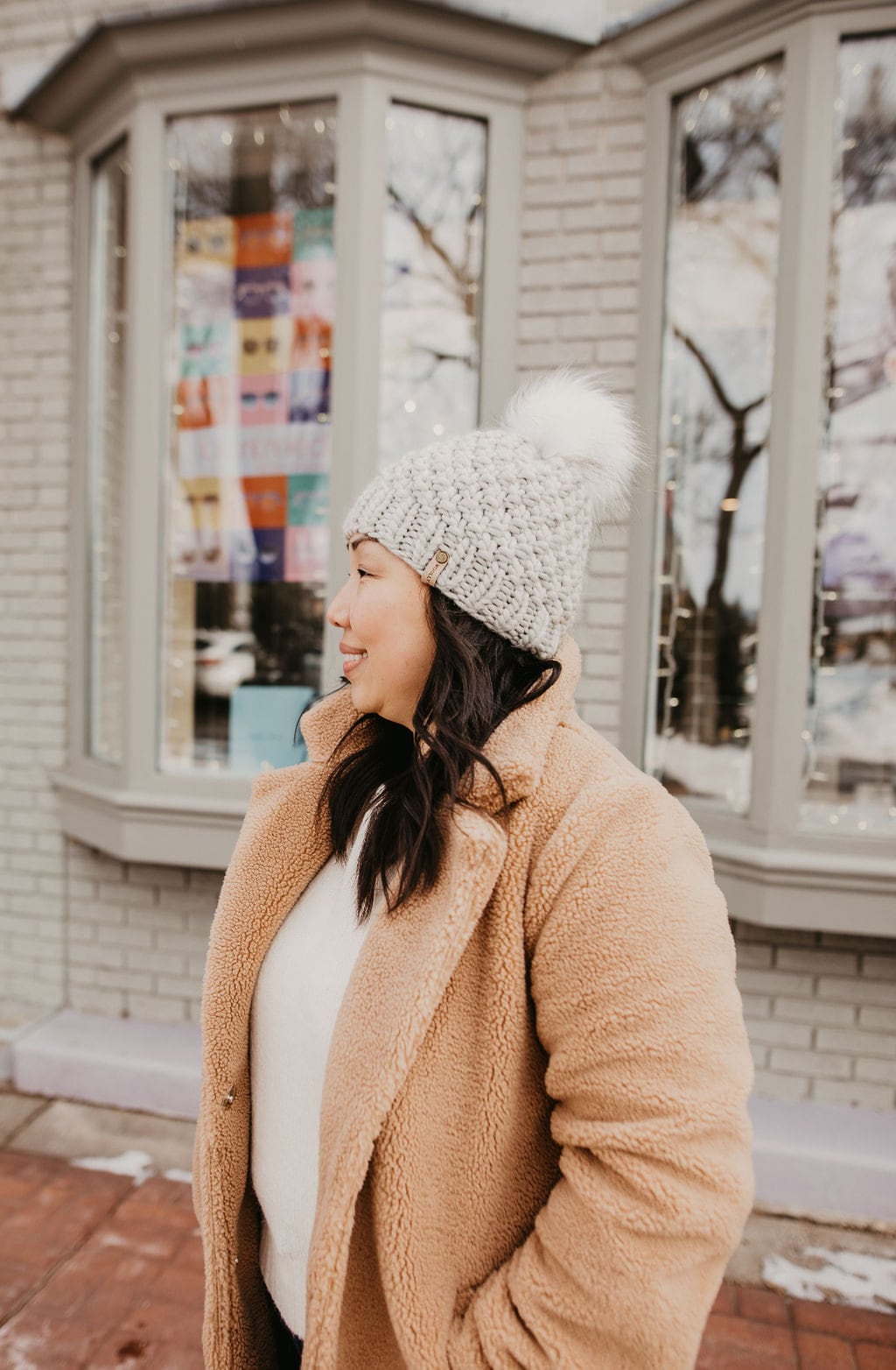 Light gray Peruvian wool knit hat with faux fur pom pom by Woolly Bear Knits, showcasing cozy warmth and stylish design.