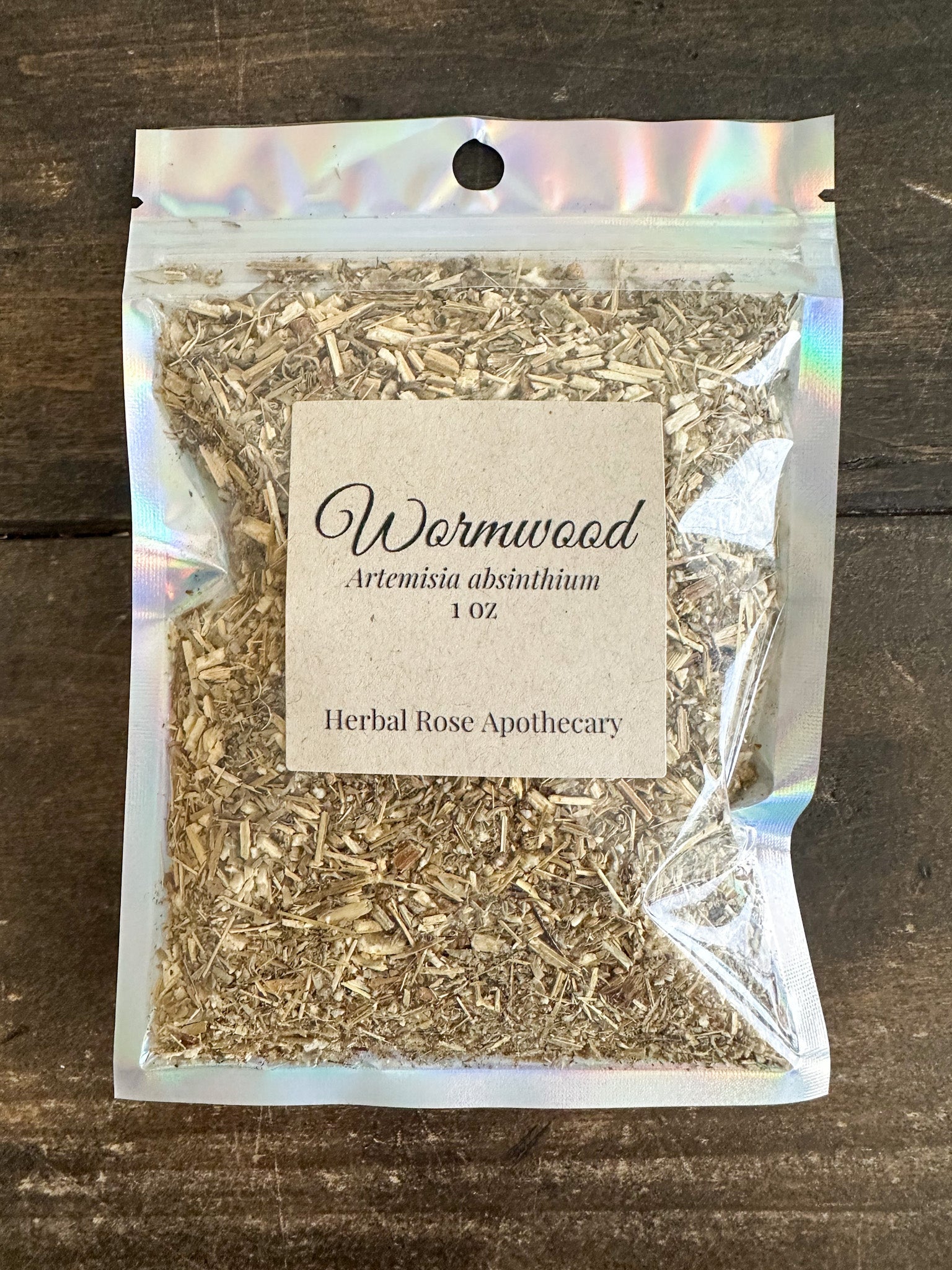 Dried wormwood herb in a 1oz package from herbalroseapothecary, showing green, leafy wormwood with textured leaves.