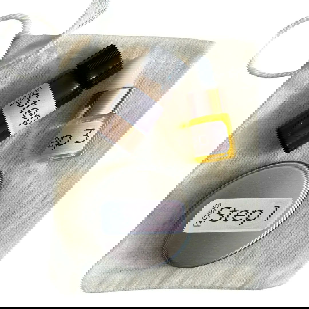 The Dewy Skincare Set by Your Only Earth includes a gray drawstring pouch, black marker, white eraser, and a silver oval SeQ—perfectly arranged for organizing your natural facial cleanser or sustainable skincare items.