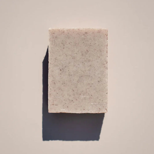 An Every Now & Zen Soap bar by Your Only Earth, with calming sandalwood and light speckles, rests on a neutral background. It casts a left shadow, indicating right-side lighting.