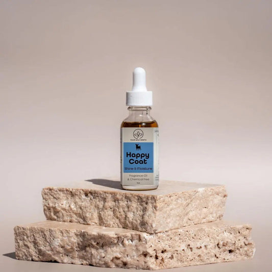 A Happy Coat glass dropper bottle from Your Only Earth sits on stone slabs against a neutral backdrop, highlighting Shine & Moisture. Its a chemical-free, fragrance oil perfect for non-toxic dog soap enthusiasts.