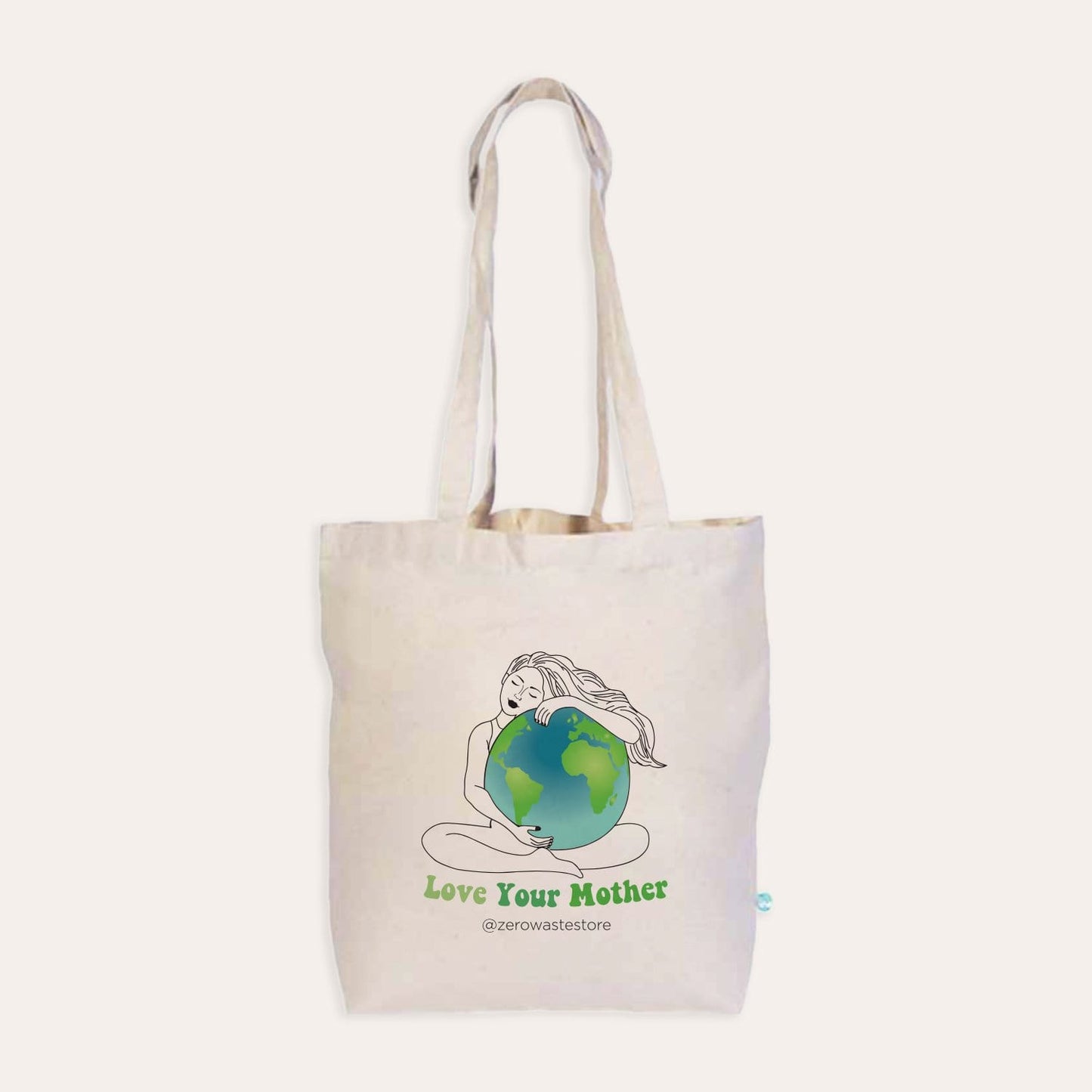 The Love Your Mother Organic Tote Bag by ZeroWasteStore.com is a beige cotton tote with a woman hugging the Earth and "Love Your Mother" plus @zerowastestore in green—an eco-friendly choice for shopping or daily use.