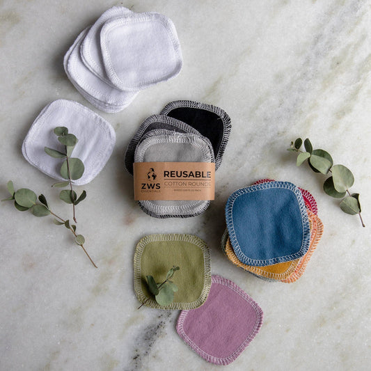 ZeroWasteStore.com Reusable Cotton Rounds—organic and colorful, displayed on marble with eucalyptus—are ideal for zero waste beauty routines.