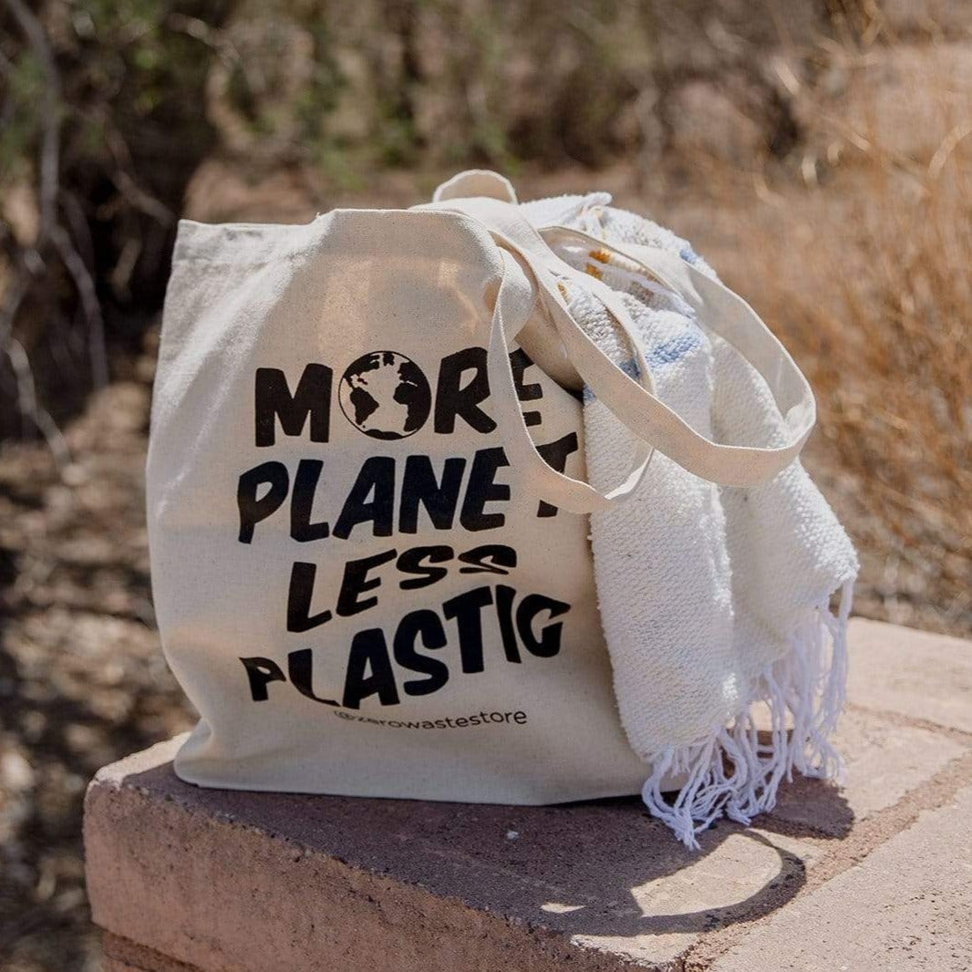 Organic tote bag from ZeroWasteStore.com with "More Planet Less Plastic" print, durable cotton shopping tote for eco-friendly use.